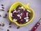 Salad with boiled beets, sunflower and pumpkin seeds and feta cheese in a yellow ceramic salad bowl, seasoned with vegetable oil