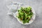 Salad bowl mache leaves baked tomatoes concrete background top view