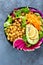 Salad Buddha bowl with fresh cucumber, avocado, watermelon radish, raw carrot, lettuce and chickpea for lunch