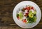 Salad with cheese, cabbage, pepper, tomato and cucumber on wooden table. with copy space. top view