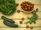 Salad, cherry tomatoes in a wicker basket, cucumbers and arugula on a wooden background.