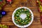 Salad Christmas wreath and Christmas decorations on wooden table. Top view