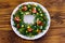 Salad Christmas wreath on wooden table. Top view
