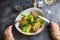 Salad with citrus, lettuce and grilled chicken liver in a plate and feminine hand.