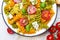 Salad with colorful pasta, cherry tomatoes, feta cheese and fresh basil