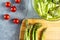 Salad components: asparagus, cherry tomatoes; wooden cutting board, grey background