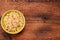 Salad of couscous, spices and tomato tabbouleh in a yellow plate on a wooden background