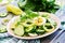 Salad of eggs and cucumbers with green onions and basil.