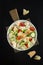 Salad fattoush with pita bread, fresh vegetables on white plate on the wooden stand. Traditional middle eastern or lebanon food