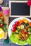 Salad with fish and vegetables on a white plate decorated with tomatoes, herbs and sweet peppers home kitchen