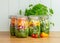 Salad in four glass storage jars.