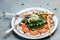 Salad of fresh arugula, tomatoes and soft Italian cheese burrata with green pesto. banner, menu, recipe place for text, top view