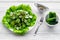 Salad with fresh cucumbers and lettuce near gravy boat. Grey wooden background