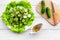 Salad with fresh cucumbers and lettuce near gravy boat. Grey wooden background top view