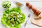 Salad with fresh cucumbers and lettuce near paperbox and gravy boat. Grey wooden background