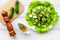 Salad with fresh cucumbers and lettuce near paperbox and gravy boat. Grey wooden background top view