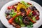 Salad with fresh cucumbers, tomatoes and greens with grilled meat on a plate Wooden board.