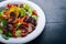 Salad with fresh cucumbers, tomatoes and greens with grilled meat on a plate Wooden board.