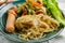 Salad of fresh vegetables on a plate with leaves, next to toasted pasta spaghetti with egg and meat sausage, a Hearty lunch, every