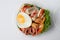 Salad, fried egg, bacon, tomato is packed in a circular plastic box