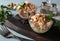 Salad with ham, olives, corn and pineapples in transparent salad bowls on wooden board. Horizontal format