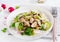 Salad king oyster mushrooms with sesame seeds, radish and lettuce on a plate.