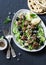 Salad with lamb meatballs, avocado, greek yogurt sauce, couscous and whole grain flatbread on a dark background, top view.