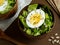 Salad of lettuce leaves and eggs in wooden bowls seeds cumin loaves Dark background