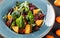 Salad with liver, arugula, orange, spinach and almonds on plate over dark stone surface. Healthy food concept. Top view