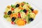 Salad made with tortellini, olives, broccoli, red pepper, on a plate