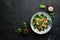 Salad with mushrooms, spinach, Turkish peas and onion in a plate on a wooden background Top view.