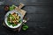 Salad with mushrooms, spinach, Turkish peas and onion in a plate on a wooden background Top view.