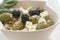 Salad of olives in a white bowl.