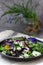 Salad of pansies and herbs seasoned with vegetable oil, lemon juice and spices