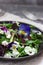 Salad of pansies and herbs seasoned with vegetable oil, lemon juice and spices