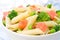 Salad with pasta, smoked salmon, broccoli, green peas closeup