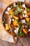 Salad with persimmon, arugula and cheese close-up. vertical top