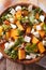 Salad with persimmon, arugula and cheese closeup. vertical top v