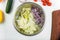 Salad preparation: iceberg salad, Peking cabbage and chopped red onion