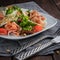 Salad with prosciutto and parmesan. Cherry Tomatoes, cutlery, knives, forks, and pine nuts on the table. Square photo