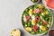 Salad with prosciutto, parmesan, olives, eggs and arugula in a plate on a gray background. Italian food. top view