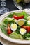 Salad with quail eggs and arugula on beige plate