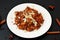 Salad with red quinoa,apple and carrot with almond on white plate on black background