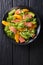 Salad of salmon, oranges, avocado and frisee close-up on a plate