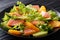 Salad of salmon, oranges, avocado and lettuce frisee close-up on