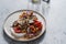 Salad with seasonal vegetables, roasted eggplants, tomatoes and greek yogurt, chickpeas and sunflower seeds