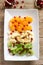 Salad of slices of various fruits and pomegranate seeds on a wooden background