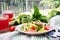 Salad of tomatoes and cucumbers with green onions and basil.