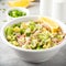 Salad with tuna, avocado, onion, egg and lemon. Spring healthy delicious lunch on light background