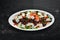 Salad with veal, spinach, tomatoes and Parmesan cheese. On a wooden background.